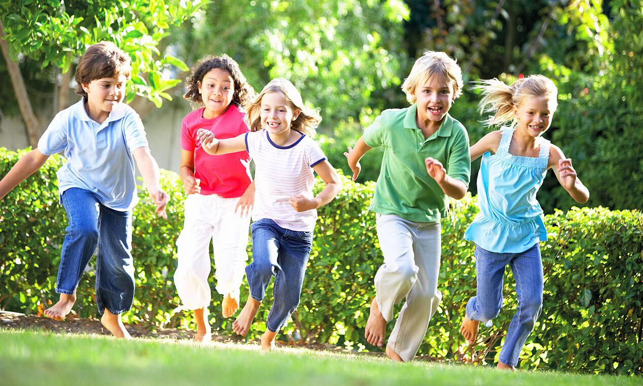 Gruppe von laufenden Kindern auf einer Wiese